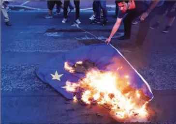  ?? VICTORIA MORCK MADSEN/AFP ?? A protester burns an EU flag outside the European Comission in Athens last year.
