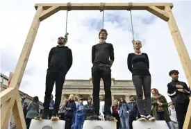  ?? FOTO: JOHN MACDOUGALL ?? I Berlin hade tre protestera­nde personer ställt sig på smältande isblock
■ framför Brandenbur­ger Tor.