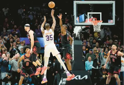  ?? ?? Phoenix Suns forward Kevin Durant shoots the game-winning basket as Bulls forward Patrick Williams defends during the second half Monday in Phoenix.