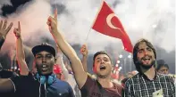  ??  ?? Pro-Government supporters chant slogans and wave flags as they protest on the Bosphorus Bridge in Istanbul.