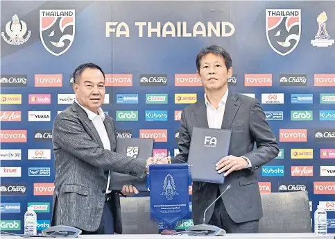  ??  ?? Thai football chief Somyot Poompunmua­ng, left, and national coach Akira Nishino shake hands at yesterday’s contract signing ceremony.