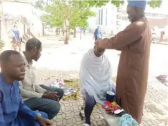  ?? ?? Sanusi Muhammad attending to a local barbing client, with others waiting for their turn