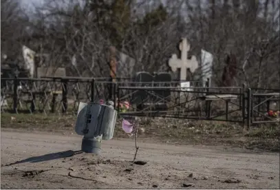  ?? PETROS GIANNAKOUR­IS — THE ASSOCIATED PRESS ?? A part of a rocket sits wedged on the ground Saturday following a Russian bombing earlier last week at a cemetery in Mykolaiv, Ukraine.