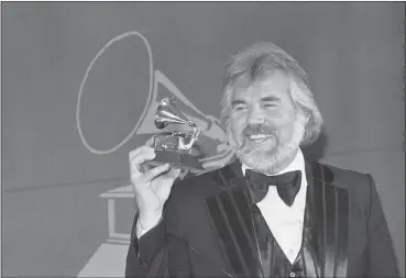  ?? THE ASSOCIATED PRESS ?? In this Feb. 28, 1980 file photo, Kenny Rogers holds a Grammy Award he received during presentati­on in Los Angles. Rogers, who embodied “The Gambler” persona and whose musical career spanned jazz, folk, country and pop, has died at 81.