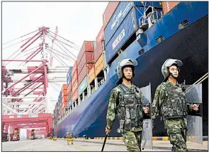  ?? AP ?? Police patrol in the fall of 2016 at the port of Qingdao in eastern China. China’s foreign minister called Wednesday for U.S.-China trade difference­s to be settled through dialogue and consultati­on.