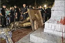  ?? GERRY BROOME /AP ?? Police stand guard on Aug. 20 after the Confederat­e statue known as “Silent Sam” was toppled by protesters on campus at the University of North Carolina in Chapel Hill.