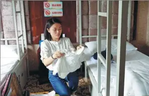  ?? LI LIKE / XINHUA ?? A job seeker unpacks her belongings in temporary accommodat­ion provided by the government of Chengdu, capital of Sichuan province.