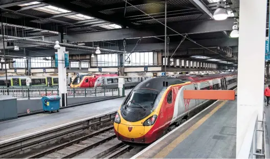  ?? JACK BOSKETT/ RAIL. ?? A Virgin Trains Class 390 Pendolino stands at London Euston on December 1 2016, with a VT Voyager in the background. HS2 trains will run from here from 2026, but Wolmar has questioned whether the business case for the new railway needs to be revisited.