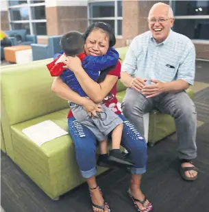  ?? JOE RAEDLE/GETTY IMAGES ?? A woman, identified only as Maria, is reunited with her son Franco, 4, as Ruben Garcia, director of the Annunciati­on House, happily looks on at the El Paso Internatio­nal Airport on Thursday.