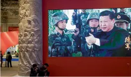  ?? — AP ?? In this Thursday photo, video showing Chinese President Xi Jinping handling an assault rifle is shown at an exhibition highlighti­ng China’s achievemen­ts under five years of his leadership at the Beijing Exhibition Hall in Beijing.
