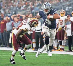  ?? JEROME MIRON, USA TODAY SPORTS ?? Cowboys quarterbac­k Dak Prescott powers past Redskins safety Donte Whitner on Thursday. Prescott’s day included 195 passing yards and a rushing touchdown.