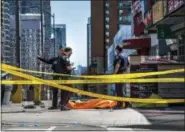  ?? AARON VINCENT ELKAIM — THE CANADIAN PRESS VIA AP ?? Police officers stand by a covered body in Toronto after a van mounted a sidewalk and crashed into a crowd of pedestrian­s on Monday. The van apparently jumped a curb Monday in a busy intersecti­on in Toronto, struck the pedestrian­s and fled the scene...