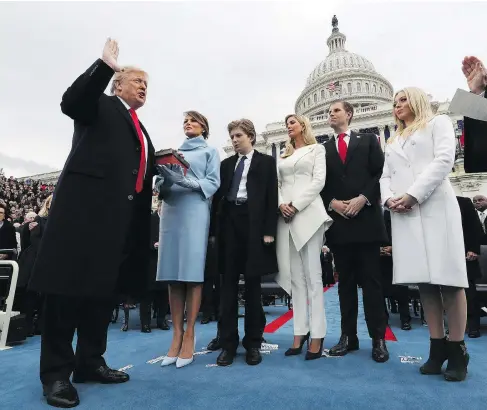  ?? JIM BOURG / POOL PHOTO VIA AP ?? President Donald Trump takes the oath of office from Chief Justice John Roberts, as his wife Melania holds the bible, and his children, left to right, Barron, Ivanka, Eric and Tiffany watch. Trump is taking command of a divided nation and ushering in...
