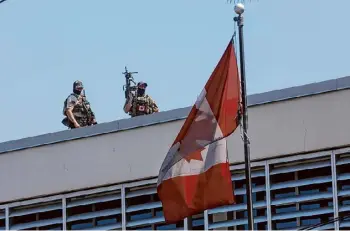  ?? Odelyn Joseph/associated Press ?? Canadian soldiers stand guard on the rooftop of their embassy in Port-au-prince, Haiti, Wednesday.