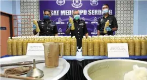  ??  ?? Unlawful substance: supt Mohd rosdi showing some of the seized ketum water during the press conference. — shaarI ChEMaT/The star