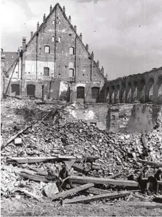  ?? Foto: Bayerische­s Landesamt für Denkmalpfl­ege/Hazold ?? Drei Bürger sitzen im April 1945 nach den verheerend­en Bombenangr­iffen auf den Trümmern des Tanzhauses.
