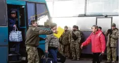  ?? Foto: A. Stepanov, afp ?? Die ersten Gefangenen verlassen den Bus, der sie zum Checkpoint an der Grenze zwi schen der Ukraine und dem abtrünnige­n Osten gebracht hat.