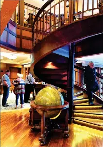  ?? ?? Among the British cruise ship's many touches that Americans may find unusual, the extensive library has a spiral staircase.