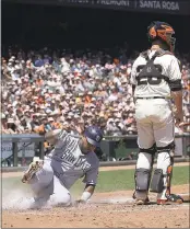  ?? JEFF CHIU — ASSOCIATED PRESS ?? San Diego’s Hector Sanchez scores while Giants catcher Buster Posey waits for a throw that never came.