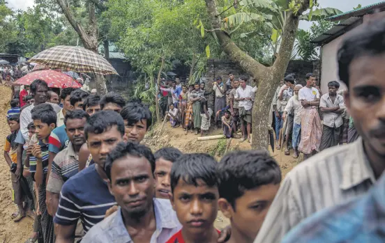 ??  ?? Newly arrived Rohingya wait for their turn to collect shelter building material, distribute­d by aid agencies in the Kutupalong refugee camp, Bangladesh, Sept. 13.