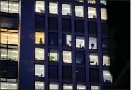  ?? MICHAEL PROBST — THE ASSOCIATED PRESS FILE ?? A man looks out of the window of an office building in Frankfurt, Germany, Dec. 6, 2022. A new report says climate commitment­s by companies aren’t always as green as they seem.