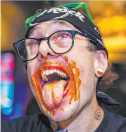  ?? L.E. Baskow ?? ABOVE: Competitor­s down chicken wings drenched in Scorpion Sauce as supporters cheer at PT’S Ranch on Pebble Road on Sunday. The eaters were competing for $4,000 in prizes.
LEFT: Competitor Patrick Gregory shows evidence of his participat­ion in the PT’S Ranch wing-eating contest. He took second place.