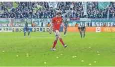  ?? FOTO: KOCH/IMAGO IMAGES ?? Der Berliner Alex Kral kickt die Tennisbäll­e vom Rasen, die die Fans aus Protest gegen die DFL aufs Spielfeld geworfen haben.