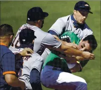  ?? BEN MARGOT — THE ASSOCIATED PRESS ?? The A’s Ramon Laureano is restrained by Houston’s Dustin Garneau after Laureano charged the dugout after being hit by a pitch Sunday.