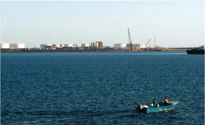  ?? (Raheb Homavandi/Reuters) ?? A SPEED BOAT passes by oil docks at the port of Kalantari in the Iranian city of Chabahar, 300 km. east of the Strait of Hormuz.