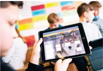  ?? FOTO: DPA ?? Schüler einer fünften Klasse lernen mithilfe ihrer iPads Englisch. Die Stadt Korschenbr­oich wartet derzeit auf die Lieferung von 320 dieser Geräte. Künftig soll auch hier Schule deutlich digitaler ablaufen.