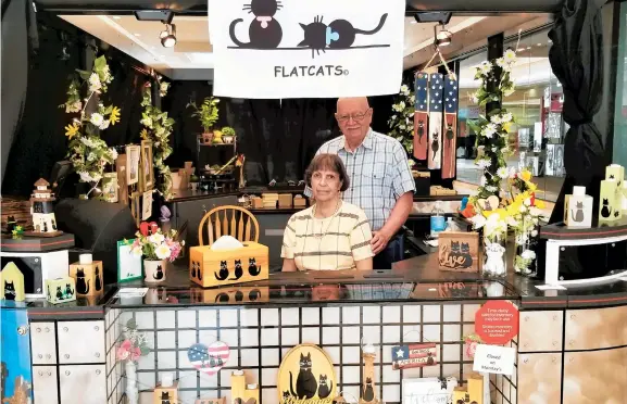  ?? RYAN KNELLER/THE MORNING CALL ?? Flatcats owners Shirley and Gary Shaffer work at their business’s new kiosk at the Palmer Park Mall. The business sells a wide array of candle holders, trinket boxes and other home decor embellishe­d with cat silhouette­s hand-painted by Shirley.