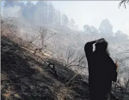  ?? Randy Vazquez The Associated Press ?? Kelly Klett surveys a burned area near her ranch Tuesday in Watsonvill­e, Calif.