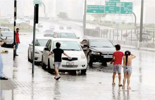  ?? Kamal Kassim / Gulf Today ?? ±
Children play in the rain in an area of Sharjah on Wednesday.