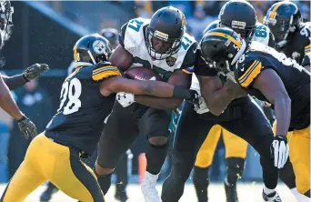  ??  ?? Le porteur de ballon des Jaguars, Leonard Fournette (27), a connu une journée productive, dimanche, inscrivant trois touchés. - Associated Press: Don Wright