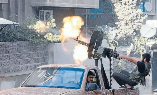  ?? Photo: REUTERS ?? Letting rip: A member of the Free Syrian Army opens fire with his machinegun during clashes with Syrian Army forces in Aleppo.