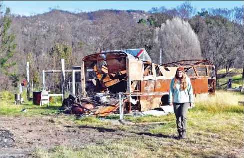  ?? AFP ?? Anita Lawrence walking in front of a charred bus near to where she lives with her five children in a makeshift shelter in Bemboka.