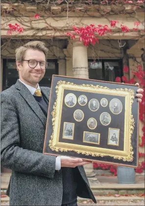  ?? PICTURE: SWNS ?? ROYAL FAMILY LIFE: Jim Spencer of Hansons holds up a collection of photograph­s commission­ed by Queen Victoria and taken by experiment­al photograph­er Alexander Lamont Henderson.