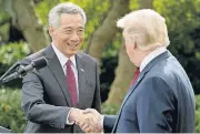  ?? [AP PHOTO] ?? President Donald Trump and Singapore’s Prime Minister Lee Hsien shake hands together following a joint statement in the Rose Garden at the White House on Monday in Washington.