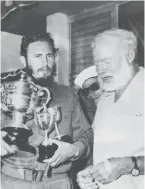  ??  ?? In this May 15, 1960 file photo, American novelist Ernest Hemingway (right) stands with Castro who holds a trophy after winning the individual championsh­ip in the annual Hemingway Fishing Tournament in Havana.