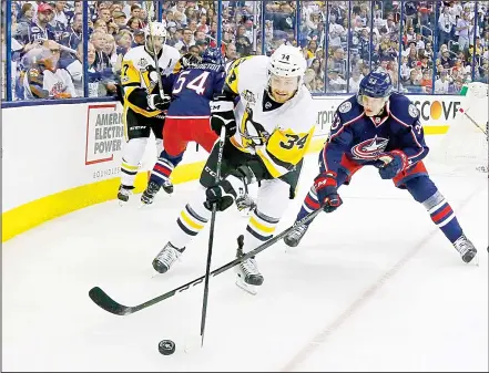  ??  ?? Tom Kuhnhackl #34 of the Pittsburgh Penguins and Gabriel Carlsson #53 of the Columbus Blue Jackets battle for control of the puck during the first period in Game Three of the Eastern Conference First Round during the 2017 NHL Stanley Cup Playoffs on April 16, at Nationwide Arena in Columbus, Ohio.(AFP)