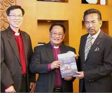  ??  ?? Courtesy
call: Musa receiving a book from Bishop Melter at the state assembly. — Bernama