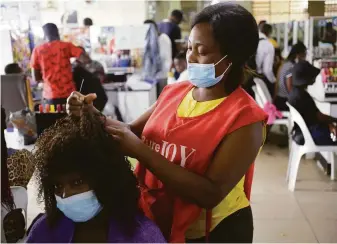  ?? Tsvangiray­i Mukwazhi / Associated Press ?? Hairdresse­r Thembi Ndlovu serves a customer last week at a salon in Harare, the capital of Zimbabwe. She, like many people in Africa, has struggled to obtain home testing kits.