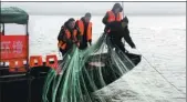  ?? LIU TAO / FOR CHINA DAILY ?? Members of a Yangtze patrol seize fishing nets placed illegally in the river in Jinzhou, Hubei.