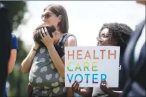 ?? ANDREW HARNIK / AP ?? Families affected by pre-existing conditions attend a news conference June 26 on Capitol Hill. Nine of the 11 states with the highest rates of pre-existing conditions among adults under 65 have signed onto the lawsuit to strike down the ACA, according...