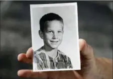  ?? CHRIS O’MEARA — THE ASSOCIATED PRESS ?? In this Wednesday photo, Greg Hunt holds a school photo of himself in St. Petersburg, Fla.