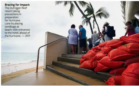  ?? — AFP ?? Bracing for impact: The Outrigger Reef resort taking precaution­s in preparatio­n for Hurricane Lane by placing sandbags at beach-side entrances to the hotel, ahead of the hurricane.