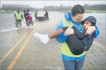  ?? CHIP SOMODEVILL­A — GETTY IMAGES ?? Volunteer Amber Hersel from the Civilian Crisis Response Team helps rescue 7-year-old Keiyana Cromartie and her family from their flooded home Friday in James City, N.C. Hurricane Florence made landfall in North Carolina as a Category 1 storm.