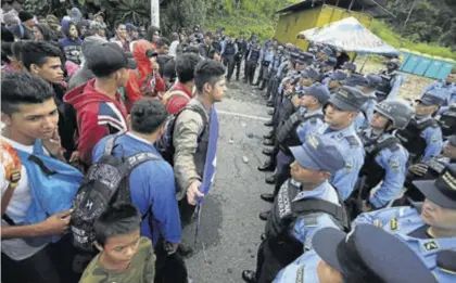  ??  ?? Cientos de policías impiden a la caravana de hondureños avanzar hacia la frontera mexicana, ayer.