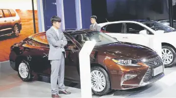  ?? — Reuters photo ?? Staff wait for visitors at Toyota’s booth during the Imported Auto Expo in Beijing.