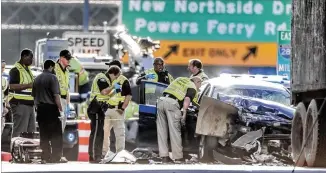  ?? JOHN SPINK / JSPINK@AJC.COM ?? Authoritie­s work the scene of a two-vehicle crash Wednesday on I-285 West in Sandy Springs that police said killed Derrien O’Neal, 33, and Sydni Hackett, 31, both of Atlanta.